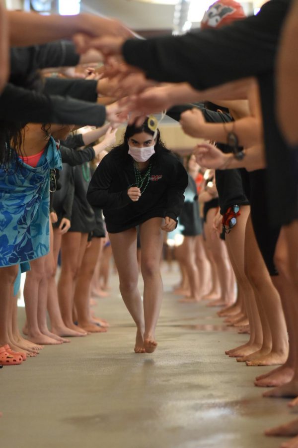 Senior Carolina Larricella is recognized at the swim meet.  All seniors run through an arch, and are featured on a video board.