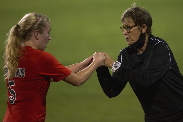 Coach Whitlock congratulates a player as she comes off the field.