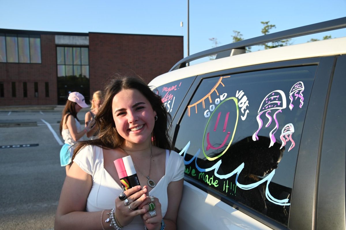 Senior Camila Sanchez poses by decorated car window for Student Councils Senior Car Decorating.