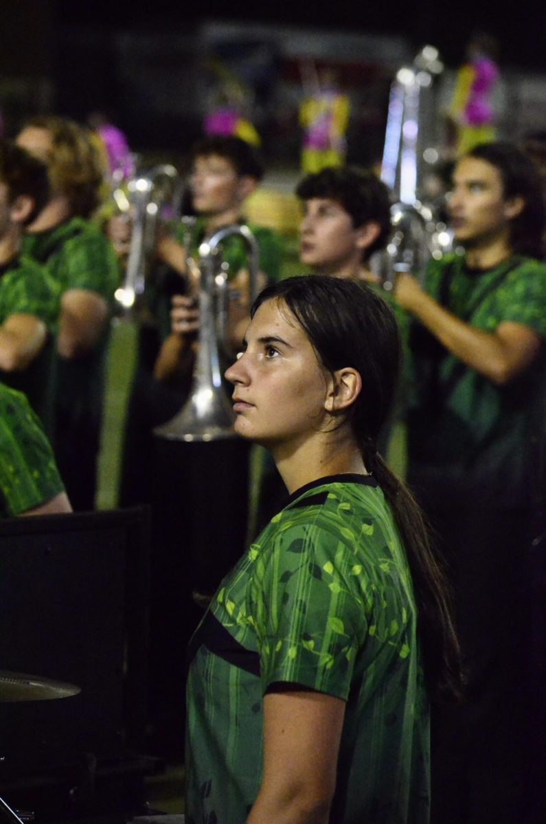 Junior Addison May and her fellow band members look up during their performance at a high school football game.