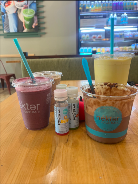 Nekter Juice Bar Items (from left to right): Berry Banana Burst, Peanut Butter Mocha Smoothie, Power 40 Shots (Vitamin D and Gut Health), Chocolate Bowl, and Mango Delight Smoothie.