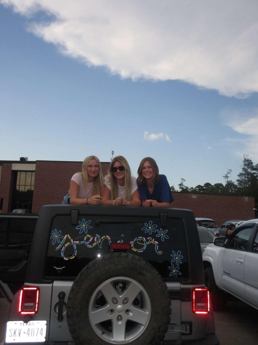 Grace Boren, Lizzie, and Stella Rhame with their painted, school spirit jeep. 