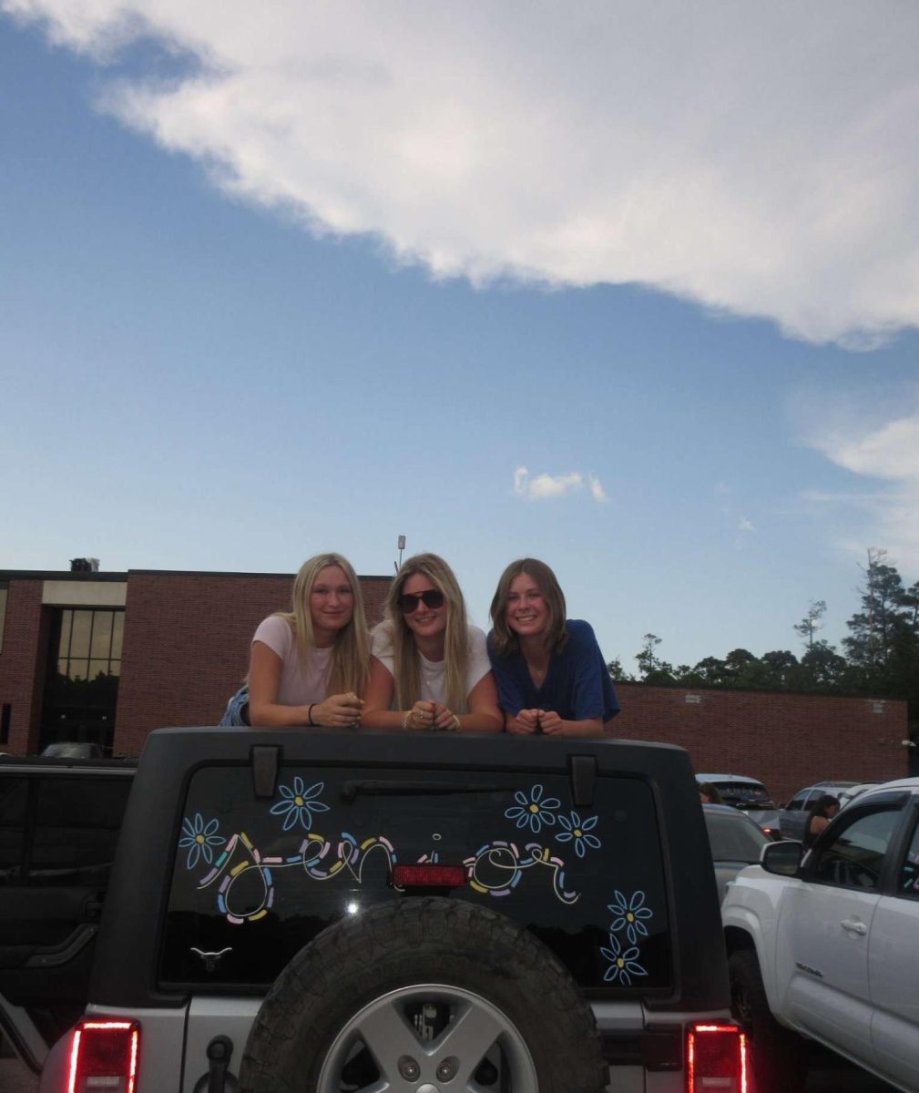 Grace Boren, Lizzie, and Stella Rhame with their painted, school spirit jeep. 