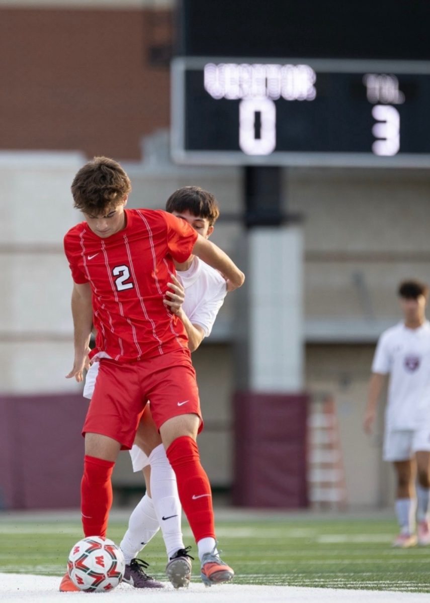 Junior Calvin Taber keeping the ball in his realm, away from his opponent. 