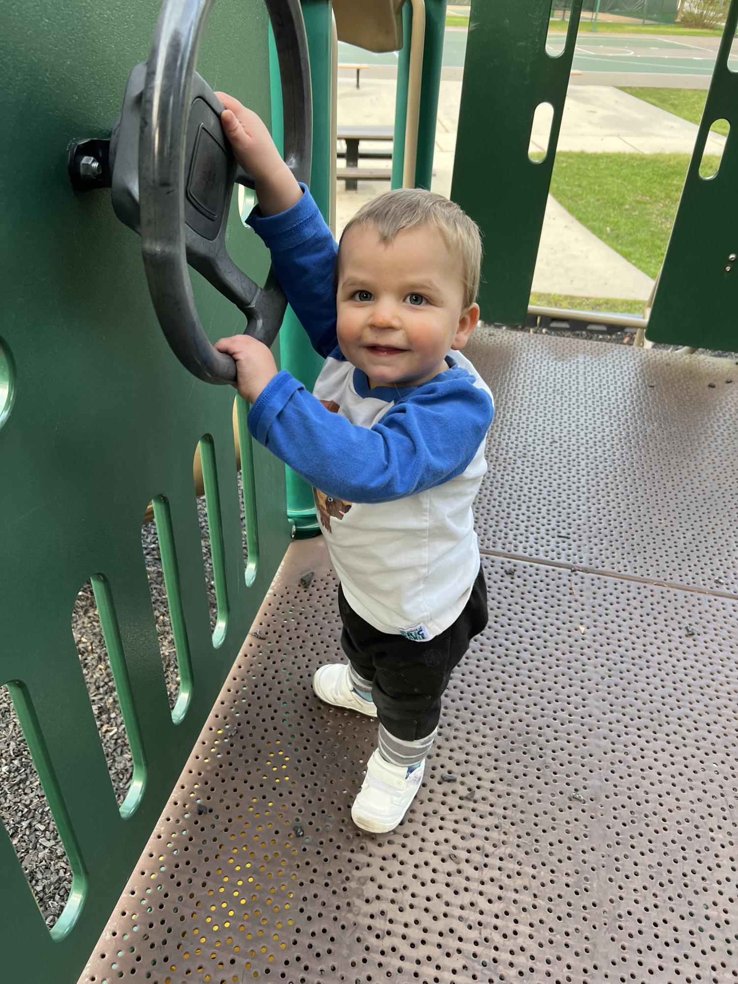Ryder playing with a wheel on a park play structure. Provided by Maggie Buckley, used with permission.