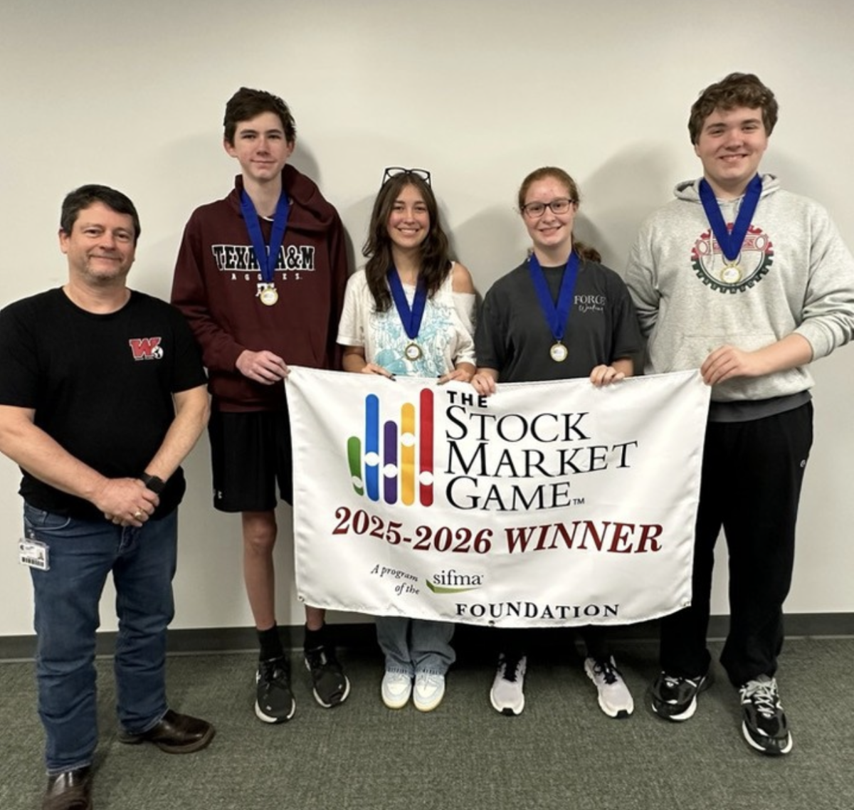 David Curington,Connor Shultz, Camille McCabe, Nicole Fountain, and William Spark holding their banner after winning the 2025 Stock Market Game. Photo from the Stockmarket Instagram, used with permission.