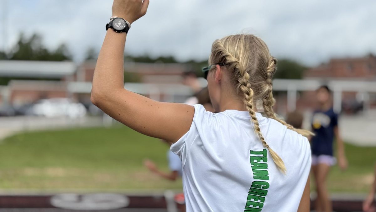 Senior Madison Hanyzewski demonstrates drills for athletes during a spring break camp hosted by Team Green Running. Hanyzewski worked with younger runners throughout the camp, helping lead workouts and teach fundamentals. Photo by April Kraushaar Green, used with permission.
